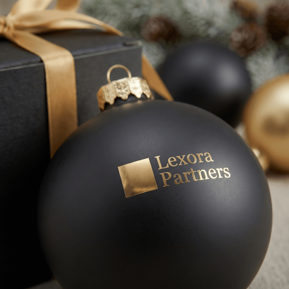 Крупный план елочного шара Lexora Partners с золотой глянцевой тампопечатью на матовой поверхности